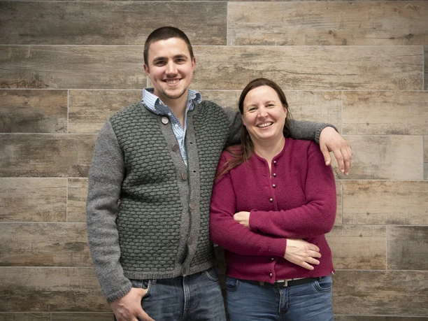 Seifenmanufaktur Wurm Zwei lächelnde Personen stehen vor einer Wand, Arm um die Schulter gelegt.