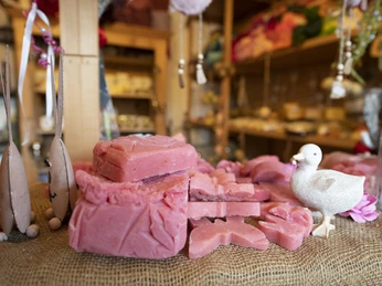 Seifen der Manufaktur Wurm Stapel rosa Seifenstücke mit Deko-Ente auf rustikalem Jutetuch.