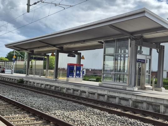 Bahnhof Rastede Moderner Bahnsteig mit Überdachung und gleisnahen Wartehäuschen an einer zweigleisigen Bahnanlage.