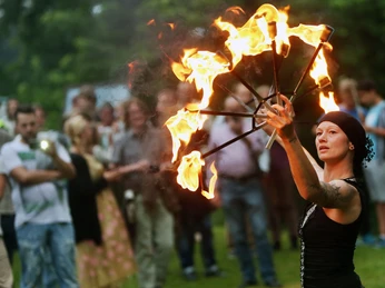 Sparrenburgfest ©Bielefeld Marketing GmbH Eine Feuerartistin führt vor Publikum auf einer Wiese einen beeindruckenden Feuertanz auf.