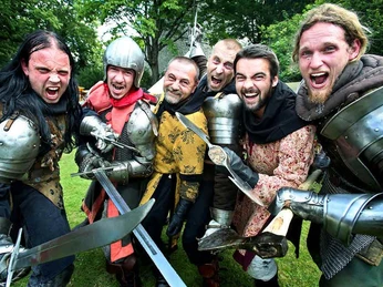 Sparrenburgfest ©Bielefeld Marketing GmbH Eine Gruppe von sechs fröhlichen Männern in mittelalterlichen Rüstungen und Gewändern hält Schwerter.