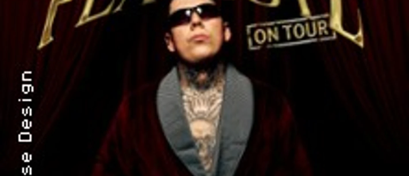 Rufuz, tätowierter Mann mit Sonnenbrille, vor einem braunen Vorhang.