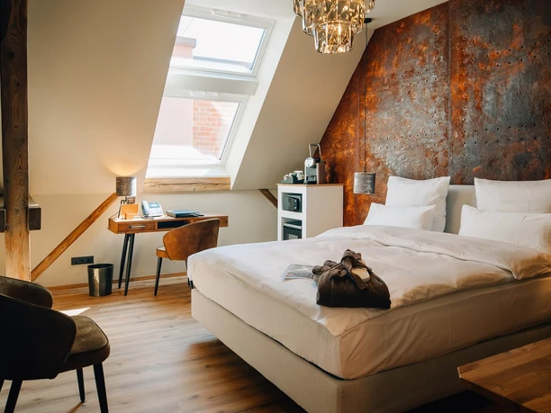 Gästezimmer in der Marienburg Monheim Modern eingerichtetes Gästezimmer mit einem großen Bett, Schreibtisch und warmem Lichteinfall.