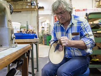 Schuhmacherei Zollner Schuhmacher bei der Arbeit in einer traditionellen Werkstatt.