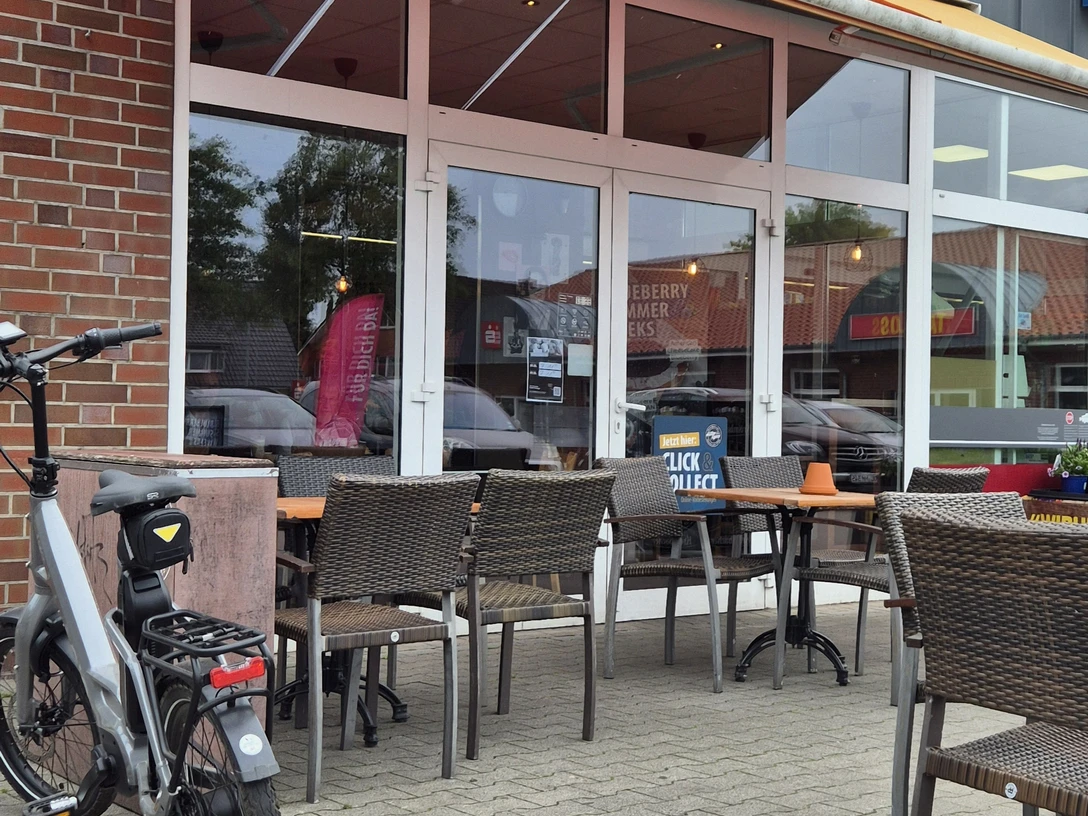 Aussenansicht Müller&Egerer Ein Café mit gemütlicher Außenterrasse, Holzmöbeln