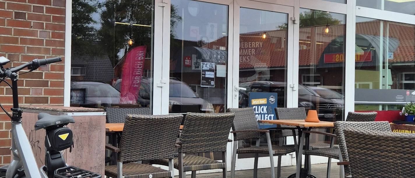 Aussenansicht Müller&Egerer Ein Café mit gemütlicher Außenterrasse, Holzmöbeln