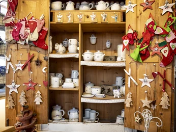 Töpferei Winsi Regal mit Keramikgeschirr und weihnachtlicher Dekoration in einer Töpferei.