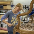 Nöh´s Raumausstattung Person bei der Restaurierung eines Holzsessels mit Drahtfedern in einer Werkstatt.