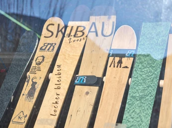Build2Ride Verschiedene individuell gestaltete Ski mit Build2Ride-Logos und witzigen Aufdrucken in einem Fenster.