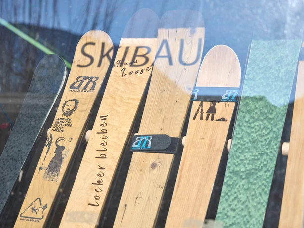Build2Ride Verschiedene individuell gestaltete Ski mit Build2Ride-Logos und witzigen Aufdrucken in einem Fenster.