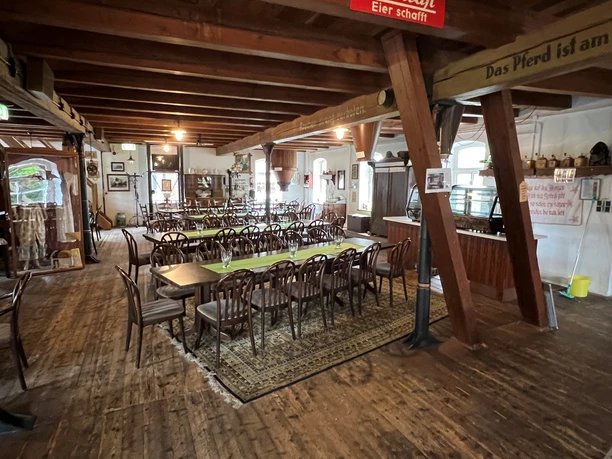 A historic mill in Lower Saxony with rustic wooden beams and plenty of tables and chairs.