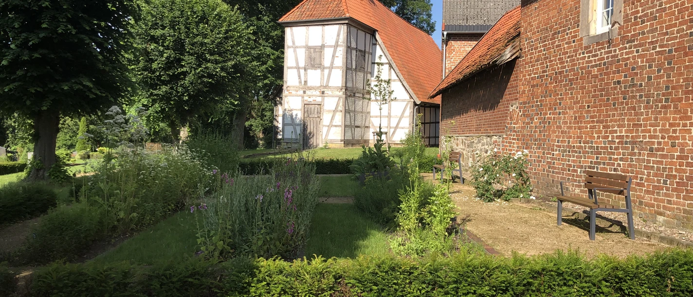 Kloster Schinna mit Fachwerk und roten Ziegeldächern, umgeben von gepflegten Gärten und Bäumen.