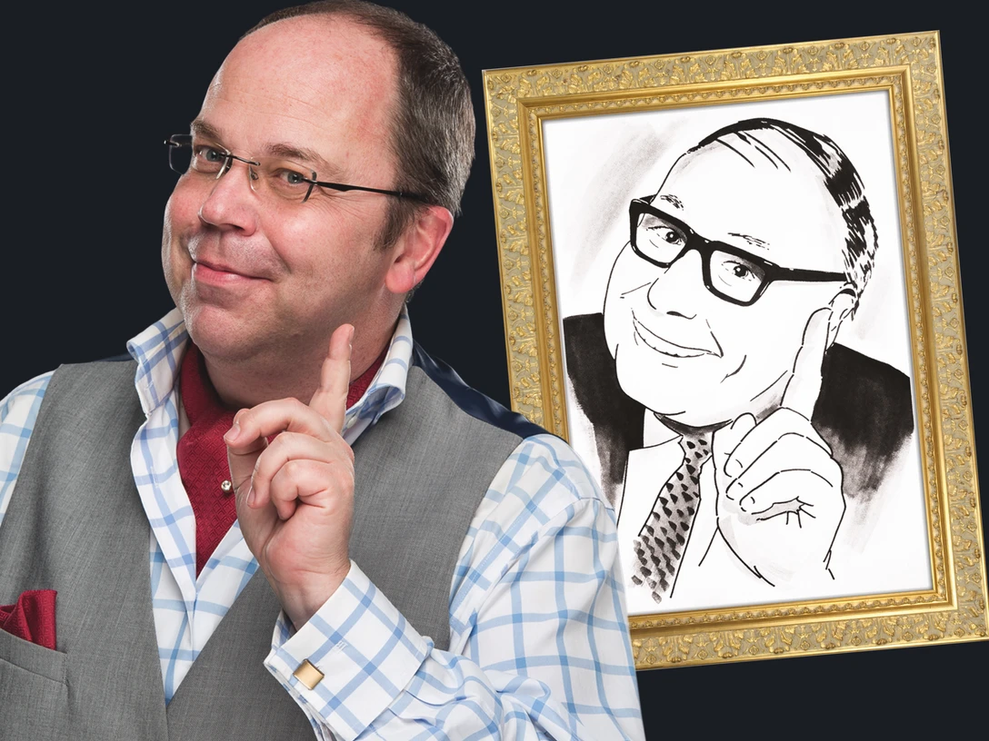 hea_a2 3MB Kopie 2.jpeg Ein Mann mit Glatze und Brille posiert lächelnd neben einem Porträt eines ähnlichen Mannes.