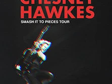 Der britische Musiker Chesney Hawkes springt in der Luft, seine Gitarre festhaltend.