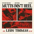 Leon Thomas spielt live Gitarre, umgeben von rotem Licht. Konzertposter für "Mutts Don't Heel".