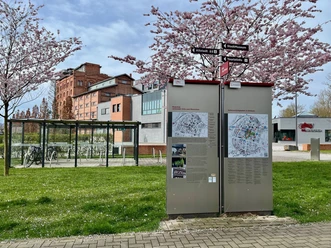 PS.Pfad, PS.SPEICHER, Frühling Die PS.Pfad Stele in Einbeck mit Wegweisern unter Kirschblüten vor dem PS.SPEICHER.
