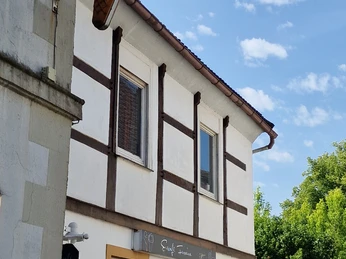 20250613_102922.jpg Fachwerkhaus mit neuem Anstrich und einem Eiscafé-Schild in Form einer großen Eistüte.