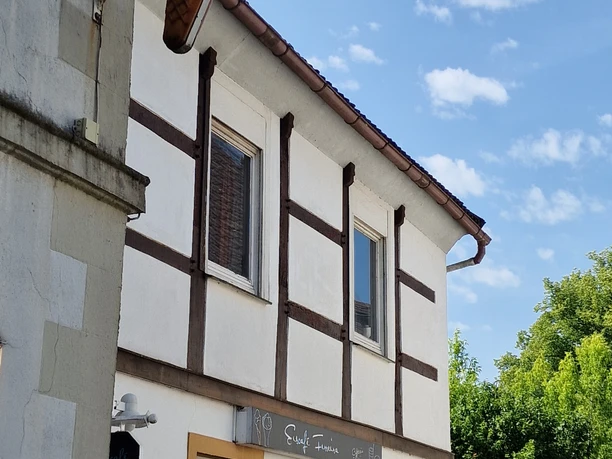 20250613_102922.jpg Fachwerkhaus mit neuem Anstrich und einem Eiscafé-Schild in Form einer großen Eistüte.