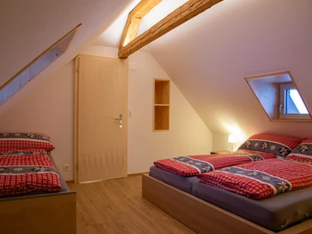 Schlafzimmer mit einem Doppelbett (180x200) und drei Juniorenbetten (90x200)