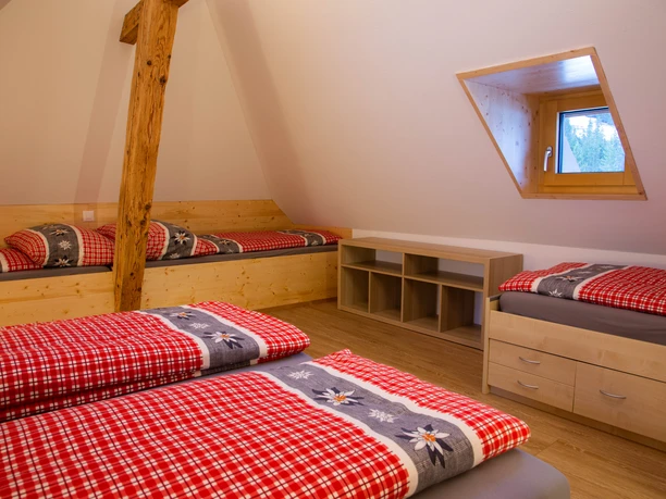 1 Schlafzimmer mit einem Doppelbett (180x200) und drei Juniorenbetten (90x200)