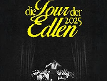 Ramzey auf einer Konzertbühne im Rampenlicht, vor einem begeisterten Publikum in dunkler Umgebung.