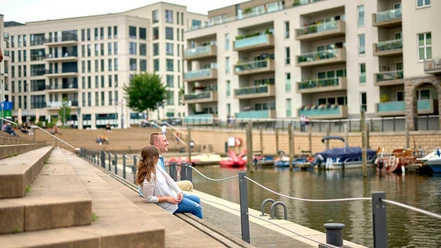Stadthafen, Mülheim an der Ruhr Zwei junge Erwachsene sitzen im Sommer auf den Treppen am Mülheimer Stadthafen