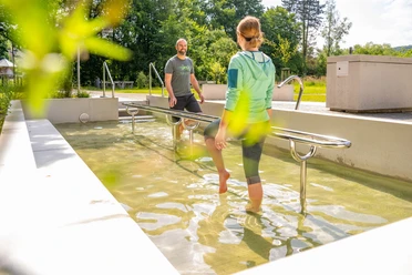 Bad Driburg-Wassertretbecken Eggeland-Park Ein Wassertretbecken im Eggeland-Park mit zwei Personen, die das klare Wasser genießen.