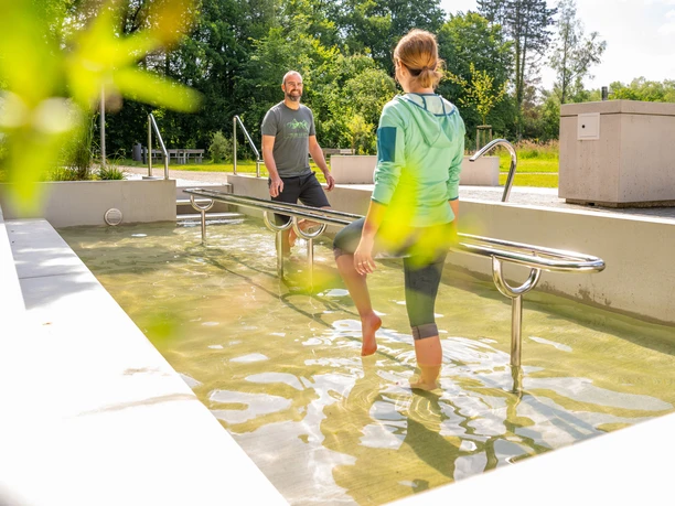 Bad Driburg-Wassertretbecken Eggeland-Park Ein Wassertretbecken im Eggeland-Park mit zwei Personen, die das klare Wasser genießen.