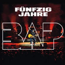 Ein Musiker performt auf einer Bühne mit farbigem Licht und der großen Aufschrift "Fünfzig Jahre BAP".