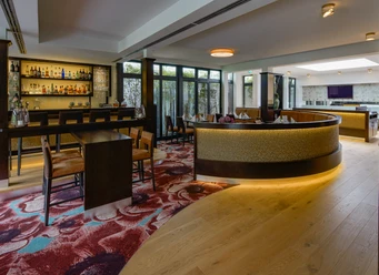 Innenraum im Restaurant merk.Mahl Moderner Innenraum eines Restaurants mit eleganter Bar, Holzboden und stilvollem Teppichmuster.