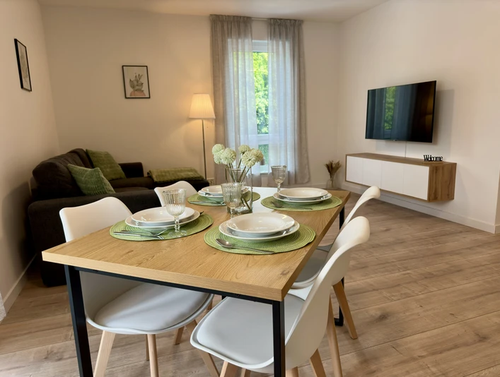 Wohnbereich.JPEG Moderner Wohnbereich mit Esstisch, bequemer Couch, Flachbild-TV und stilvoller Dekoration.