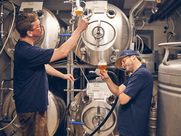 Bierbrauerei im Hotel Garmischer Hof Zwei Brauer im Hotel Garmischer Hof prüfen Bierproben vor Edelstahlbrautanks.