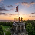 Bismarckturm Herford in abendlicher Kulisse, zwei Menschen genießen den Sonnenuntergang auf der Plattform.
