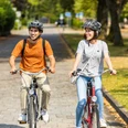 herford-promenade-teutoburger-wald-tourismus-h-tornow-008-jpg.jpg Zwei Personen radeln bei sonnigem Wetter auf einem gepflasterten Weg durch eine grüne, parkähnliche Umgebung.