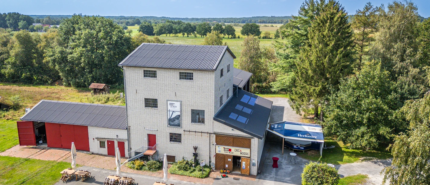 Torfwerk Hahnenmoor.jpg Ehemaliges Torfwerk mit Café und Museum inmitten grüner Moorlandschaft bei Herzlake im Emsland.