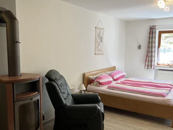 Schlafbereich mit Massagesessel und Kachelofen
