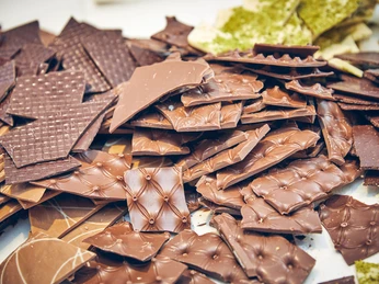 Schokoladenmanufaktur Barbara Krönner Verschiedene Schokoladenstücke in unterschiedlichen Formen und Mustern, liebevoll arrangiert.