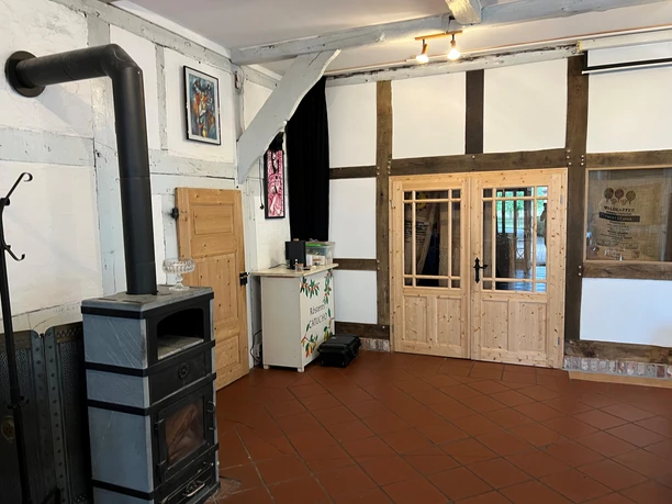 Ein gemütlicher Raum mit hölzerner, rustikaler Einrichtung und einem modernen gusseisernen Ofen.