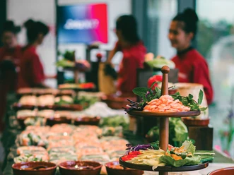 District Banh Mi GmbH Buffet with Vietnamese dishes, service staff in the background.