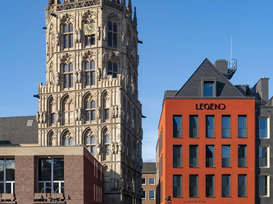 Altermarkt Der historische Rathausturm am Alter Markt in Köln erhebt sich majestätisch neben einem modernen roten Gebäudekomplex.The historic town hall tower on Cologne's Alter Markt rises majestically next to a modern red building complex.