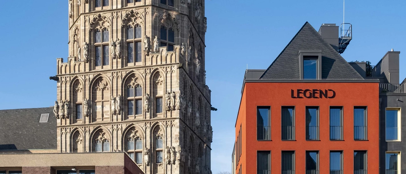 Altermarkt The historic town hall tower on Cologne's Alter Markt rises majestically next to a modern red building complex.