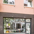 GrünBlauGrau Intérieur Die Fassade eines Geschäfts mit großen Fenstern zeigt den Schriftzug "GrünBlauGrau Intérieur" vor einem dekorierten Schaufenster.The façade of a store with large windows shows the lettering "GrünBlauGrau Intérieur" in front of a decorated shop window.