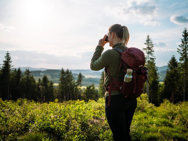 Fernblick hinter Schlossbergalm auf dem Sauerland-Höhenflug Eine Frau fotografiert die Aussicht auf dem Sauerland-Höhenflug