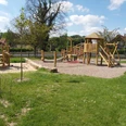 Spielplatz Begegnungsstätte Stockhausen in Lübbecke Spielplatz mit Holzklettergerüst und Rutsche in grüner Umgebung, geeignet für Kinderaktivitäten.