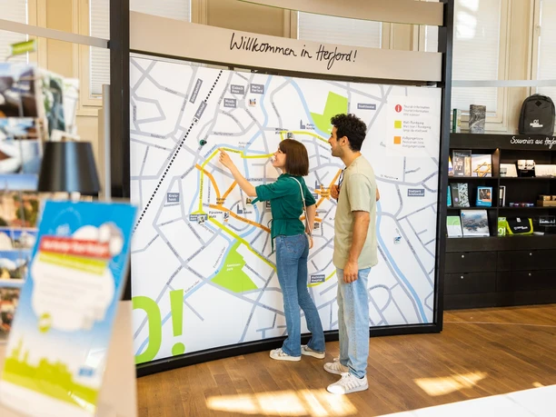 Zwei Personen betrachten eine große Karte der Innenstadt von Herford in einer Touristeninformation.