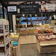 Häppchentour Markthalle_Otte (Maya Regtmeier 21).jpeg Ein Verkaufsstand in einer Markthalle präsentiert frisches Obst, Gemüse und regionale Produkte.