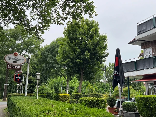 LaCucina.jpg La Cucina: gemütliches Restaurant im Grünen mit großen Bäumen, Terrassentischen und Sonnenschirmen.