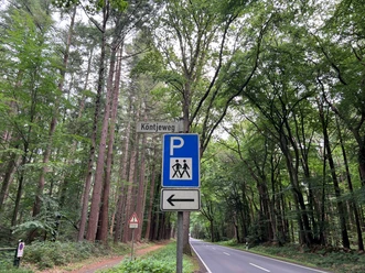 Kötnjeweg1.jpg Ein blaues Verkehrsschild zeigt einen Parkplatz an, umgeben von einem Wald am Kötnjeweg.