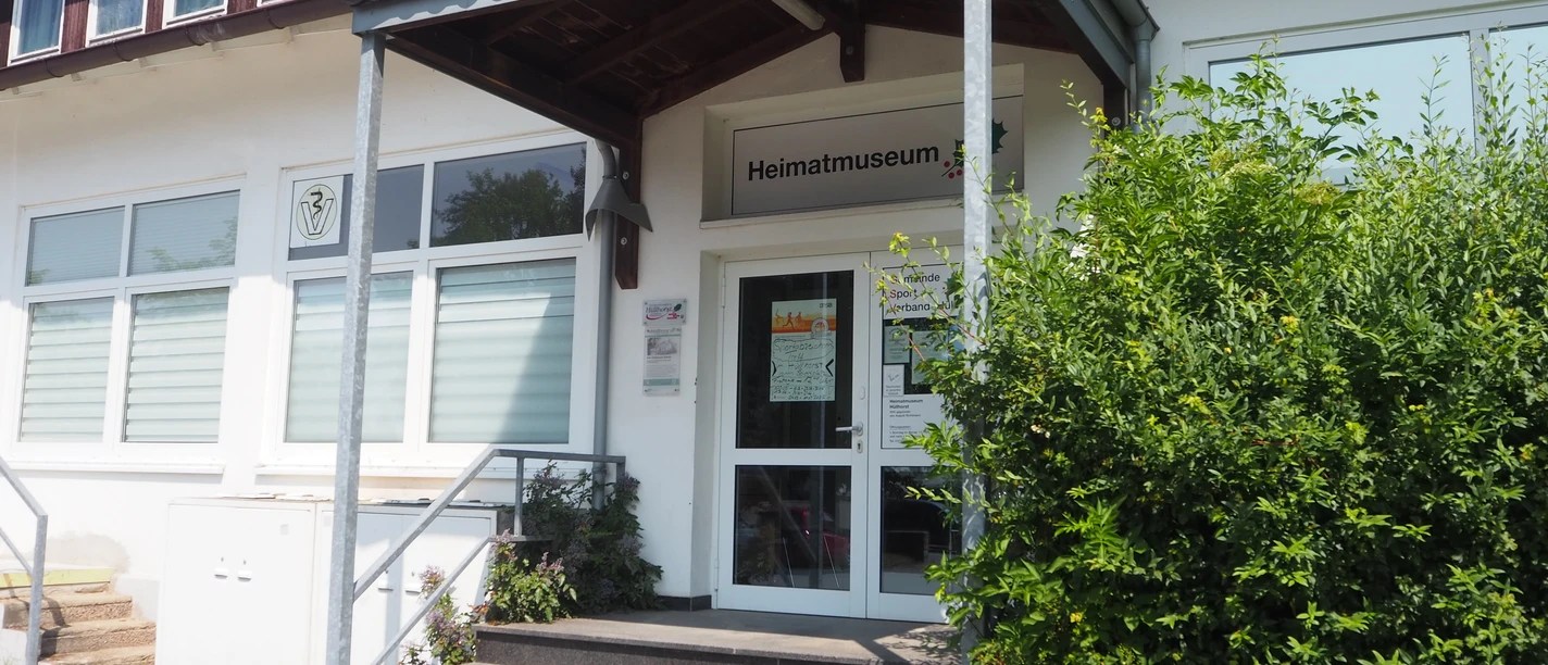Heimatmuseum Hüllhorst Eingang des Heimatmuseums Hüllhorst mit überdachtem Treppenaufgang und grüner Bepflanzung.