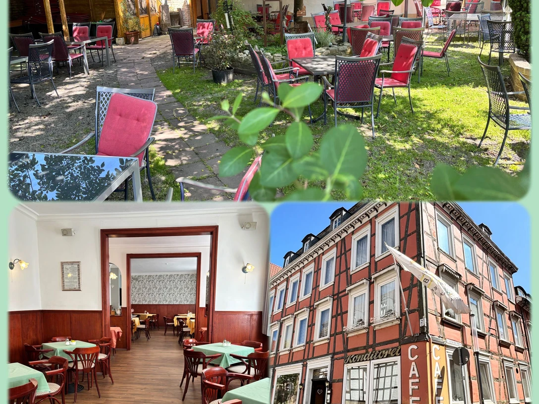 IMG-20250620-WA0006.jpg Ein historisches Café mit Außenbereich im Garten, roten Stühlen und einem Fachwerkgebäude.
